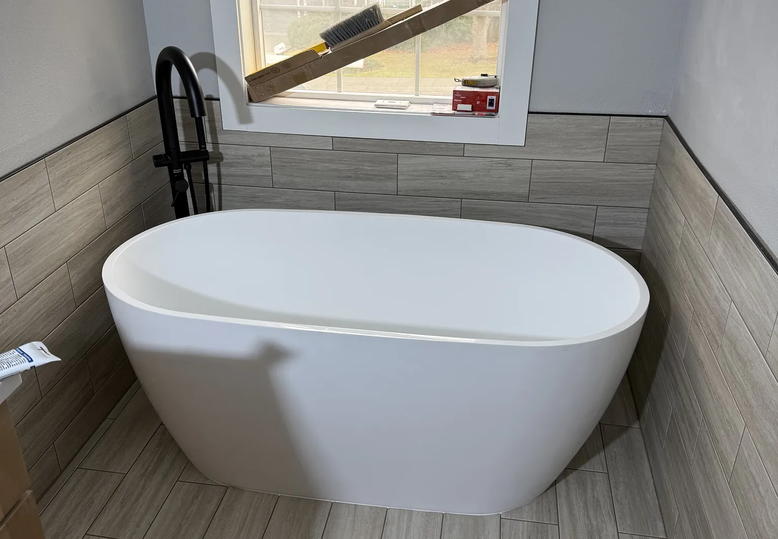 Bathtub installation with new plumbing and fixtures.